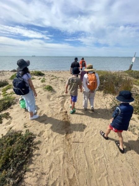 A group of people walking on a beach.
