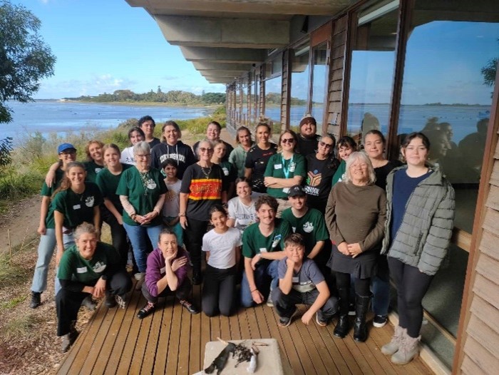 Group of volunteers gathered, smiling at the camera. The group is of volunteers and participants at a hands-on lab based workshop.